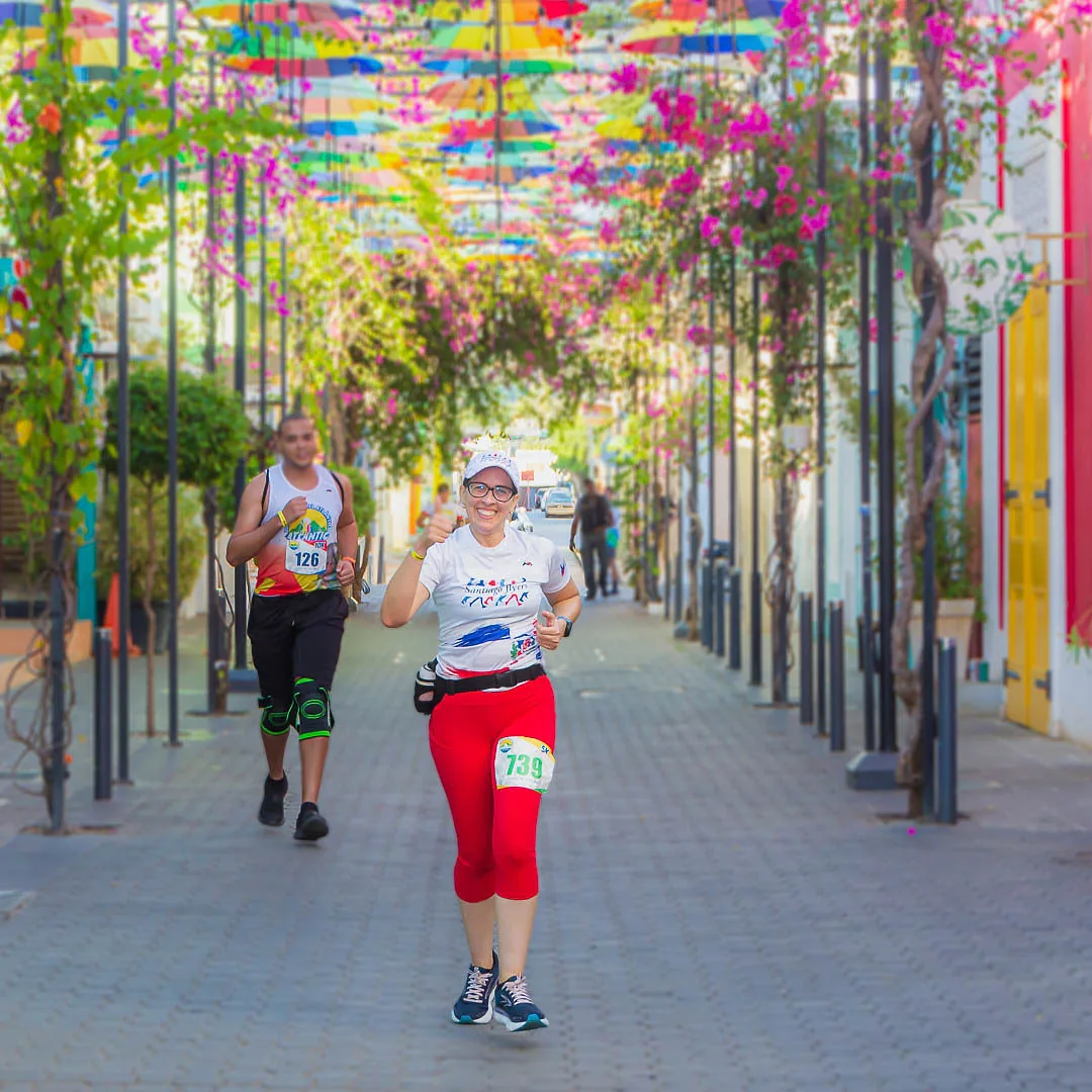 Dos corredores bajo las sombrillas de colores del centro de Puerto Plata